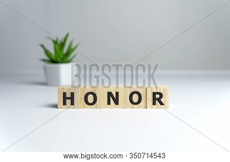 The Word Honor Written In Vintage Wooden Cubes On A White Background