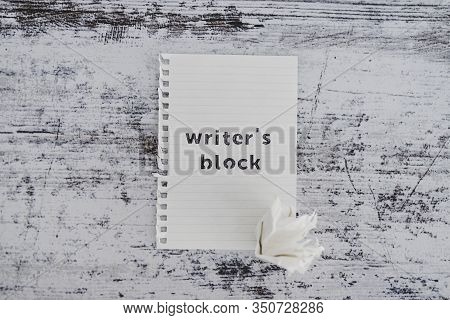 Piece Of Paper On Wooden Desk With Writer's Block Text With Scrunched Paper Ball Next To It