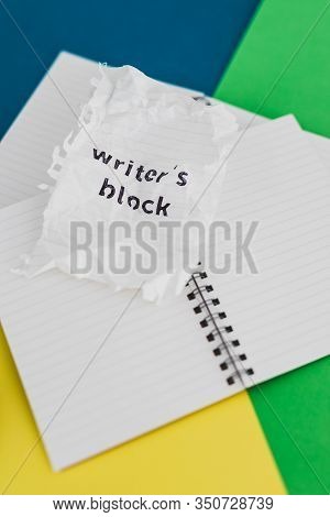 Piece Of Paper With Writer's Block Text On Top Of Blank Notepads With Pencil Eraser Scrunched Paper 