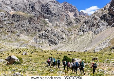 Turkey, Chamard - August 3, 2019: Tourists Walk Along The Road Through The Mountain Landscape In The