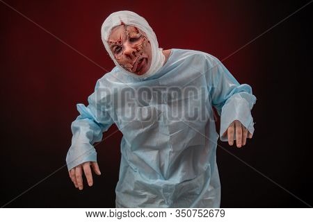 Crazy Zombie Horror Make Up. Person In Blue Madical Shirt And Bandaged Head. Scars, Deep Scratches R