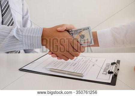Photo Of Businessmen Shake Hands And Dollar Note, Sign A Contract To Bribe Corruption In The Company