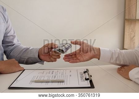A Photo Of A Businessman Who Gives Money To His Partner To Bribe The Idea Of ​​bribery And Corruptio