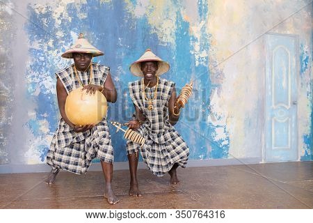 People In Traditional African Costumes Playing Jembe Drums