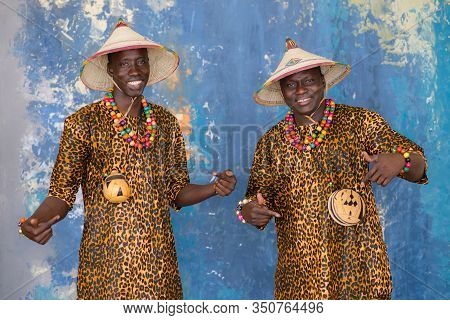 Handsome African Men In Traditional Fulani Hats And Colorful Clothes Smiling And Looking At Camera