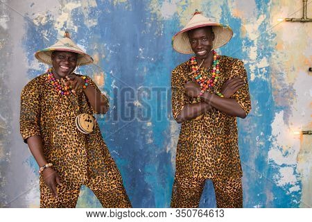Handsome African Men In Traditional Fulani Hats And Colorful Posing At Studio.