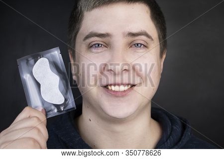 A Man Puts On And Removes A Strip For The Nose From Black Dots. Coal Cleaning Strips From Blackheads