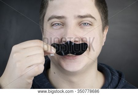 A Man Puts On And Removes A Strip For The Nose From Black Dots. Coal Cleaning Strips From Blackheads