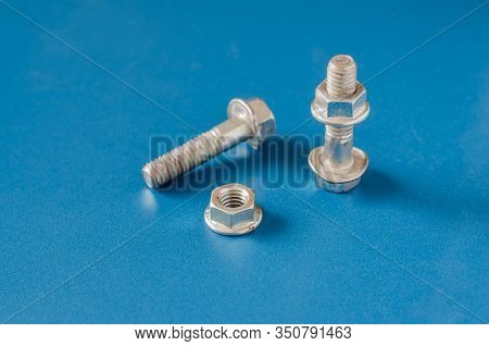 Bolts And Nuts On A Blue Background. Two Bolts And Nuts On A Blue Background.  Close-up Nut With Ski