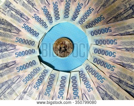A Golden Bitcoin On Vietnamese Billnotes