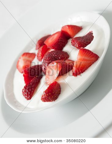 Porzellan Schale mit Erdbeeren und Sahne yogourt