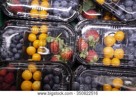 Fresh Berries Are Packed In Trays. Vitamin-rich Fruits Are Packaged In Boxes. A Variety Of Fruits Fo