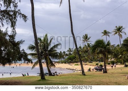 Poipu, Kauai, Hawaii, Usa. - January 11, 2012: Poipu Beach Proper Offers Brown Sand, Grassy Areas Wi