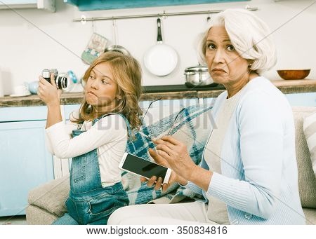 White Haired Pretty Italian Woman Looking At The Camera Trying To Understand Granddaughters New Mobi