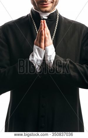 Partial View Of Catholic Priest In Black Cassock Praying Isolated On White