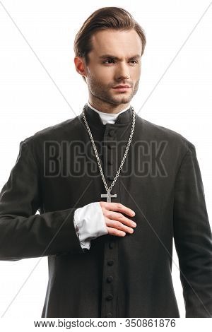 Young, Confident Catholic Priest In Black Cassock Looking Away Isolated On White