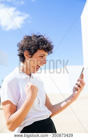 Excited Woman Holding Cell Phone Outdoor. Emotional Middle Aged Businesswoman Using Smartphone Benar