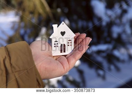 Female Hand Holding A Mock Up Of A House. White Mock Up Of A House On A Female Ladin. Close-up, Side