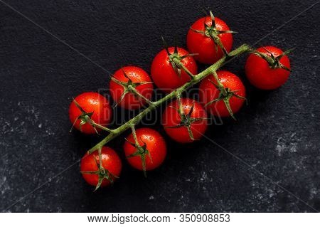 Sprig Of Red Cherry Tomatoes On A Background