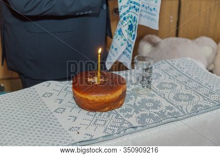 Gray Bread On A Table With A Burning Candle.