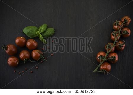 Fresh Grape Tomatoes With Pepper For Use As Cooking Ingredients On Black Wooden Background