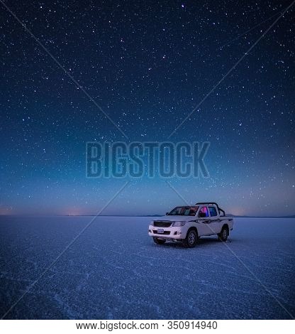 SALAR DE UYUNI / BOLIVIA APRIL 05, 2018: Off road car stays on the Uyuni salt flat during starry night