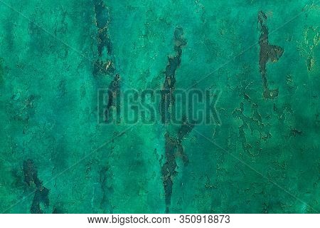 Wall With Relief Decorative Art Plaster Painted In Malachite Green Paint With Golden Yellow Streaks.