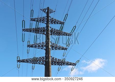 High Voltage Power Line Support With Electrical Wires On Blue Sky Background. Electricity Transmissi