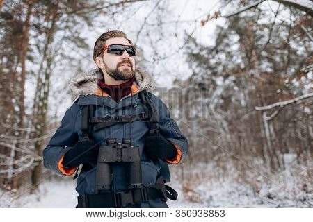Enthusiastic Hiker In Anorak And Mirrored Glasses In Snow-clad Forest