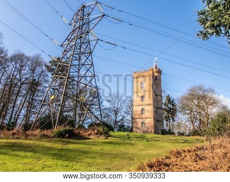 Painshill Park, Cobham Surrey, England. February 11 2020 Gothic Tower Behind Modern Electricity Pylo