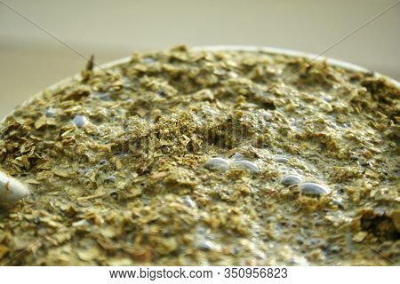 Closeup Green Yerba Mate. Flooded Yerba Mate Tea Leaves. Brewed Tea With Sticks And Tea Leaves From 
