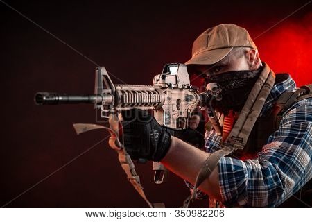 A Police Agent In Civilian Clothes And Armor With An Automatic Rifle