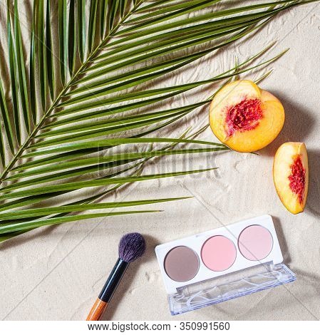 Vacation. A Sculpting Palette And A Blush Brush Lie On The Beach Sand, Surrounded By Vibrant Fruits,