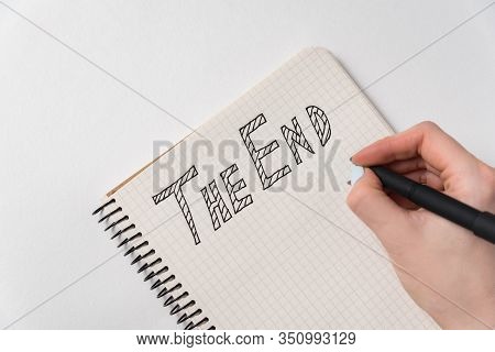 Notice In The Notebook The End. Handwritten Text. Hand With Pen And Notepad On White Background. Clo
