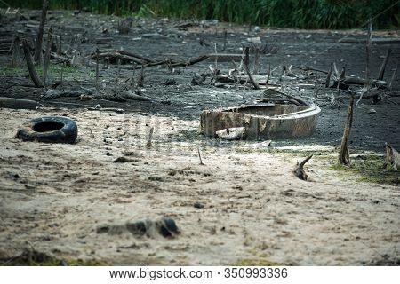Old Tires And Garbage On The Shore. Environmental Damage Contaminated Land. Ecological Disaster Conc