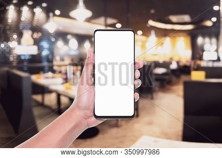Mockup Image Of Hand Holding White Screen Mobile Phone For Your Advertisement With Blurred Backgroun
