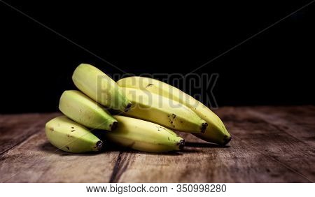 Bunch Of Ripe Bananas On A Vintage Wooden Board