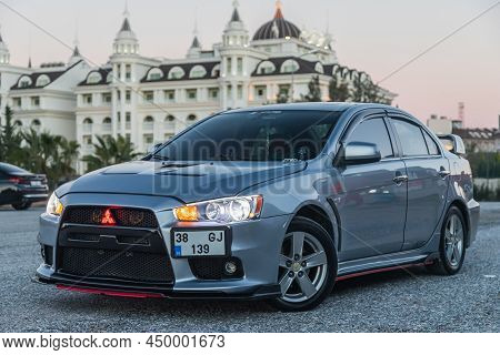 Side, Turkey - February 02 2022:  Silver Mitsubishi Lancer    Is Parked  On The Street On A Warm  Au