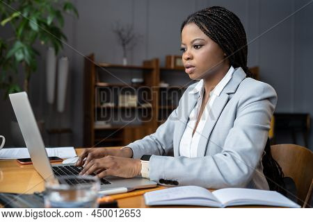 Young Focused Black Female Employee Working Hard On Laptop, African American Businesswoman Typing On