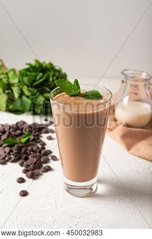 Chocolate Protein Milkshake In Glass White Kitchen Background. Delicious Portion Chocolate Milkshake