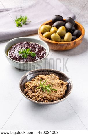 Tapenade - Paste Made From Olives. Bowls With Spreadable Black And Green Olive Cream On Concrete Bac