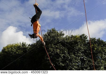 Woman Practicing Rappel On A Pedestrian Walkway.