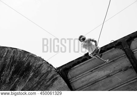 Woman Practicing Rappel On A Pedestrian Walkway.