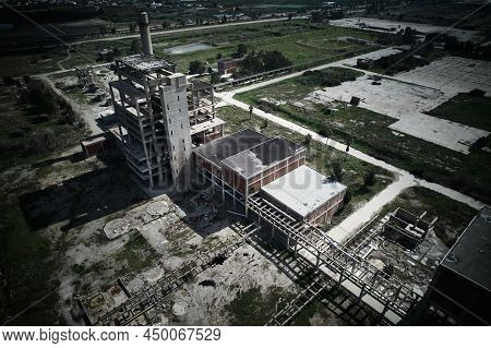 Concrete Structures Of Abandoned Plant. Chimney And Skeletons Of Abandoned Multi-storey Buildings. A