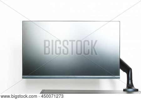 Modern Matte Computer Monitor Or Tv Set Is Mounted On A Small Table With A Metal Bracket. Off-center