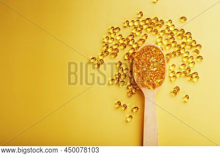 Vitamin D3 In A Wooden Spoon On A Bright Yellow Background
