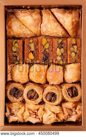 Collection Of Eastern Sweets In The Golden Box. Arabian Baklava And Ush-el-bul-bul Dessert. Top View