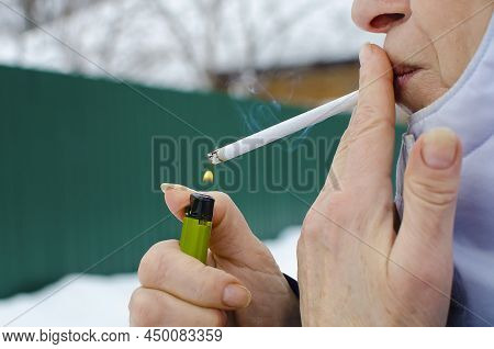Woman Is Lighting Up A Cigarette Outdoors, Close-up. The Concept Of Bad Habits.