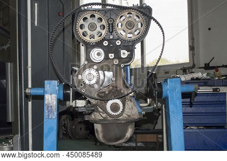 An Automobile Internal Combustion Engine With The Front Cover Removed Mounted On An Engine Repair St