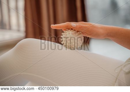 Athletic Slim Caucasian Woman Doing Thigh Self-massage With A Massage Ball Indoors. Self-isolating M